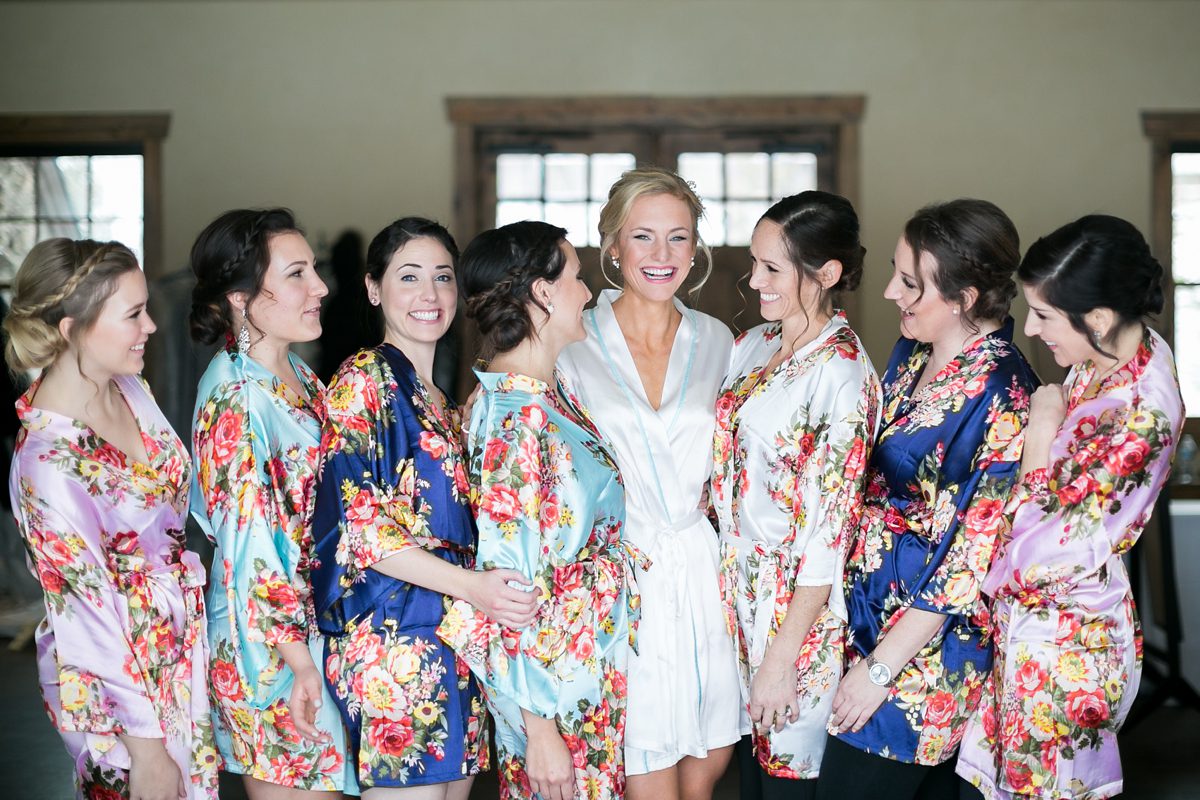 Happy bridesmaids in colorful robes, Colorado Devils Thumb Ranch Winter Mountain Wedding, Amy Caroline Photography