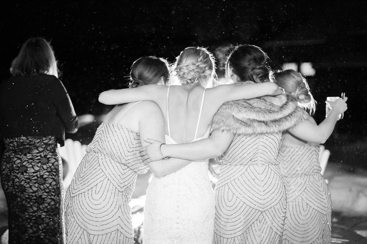 Bride and her bridesmaids around a fire pit in the snow, Colorado mountain winter wedding, Amy Caroline Photography