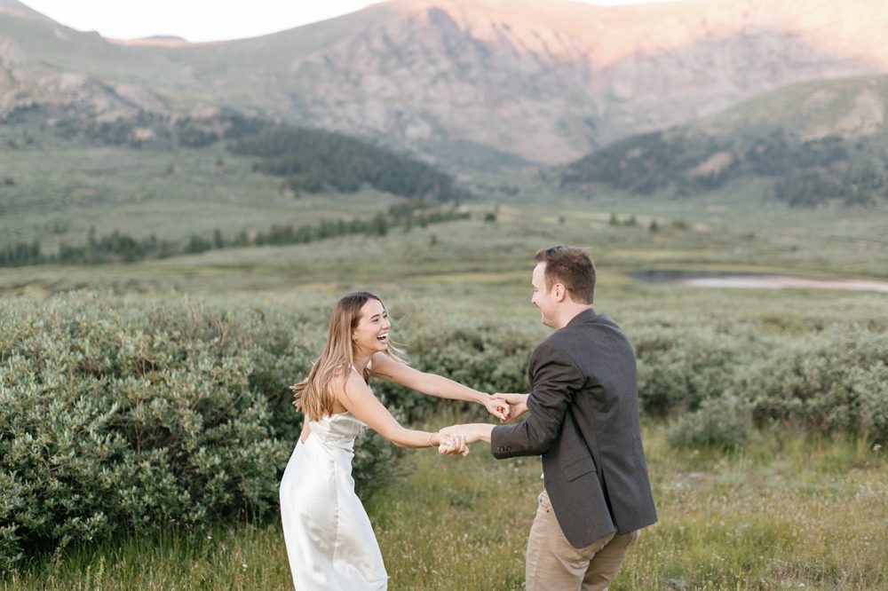 A couple laughing and dancing during their mountain engagement session in Georgetown, Colorado